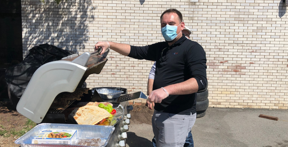 Utica Academy of Science elementary school teachers and staff working during Spring Recess fire up the grill on a sunny day for a BBQ cookout.