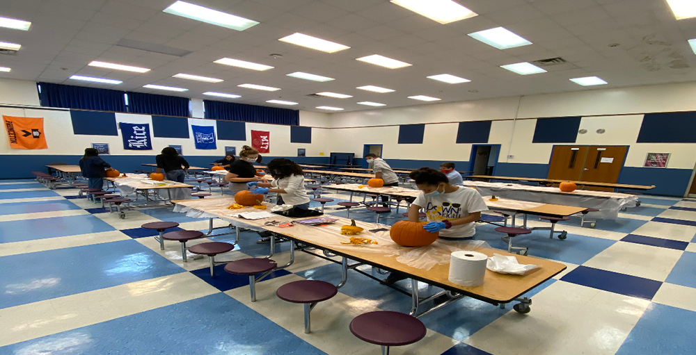 Utica Academy of Science High School students get ready for Halloween by participating in a socially distant pumpkin carving activity.